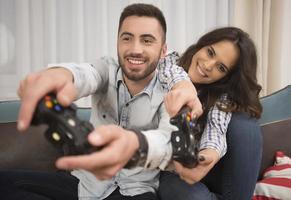 casal sorridente feliz jogando videogame em casa. foto