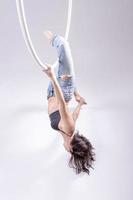 uma ginasta de aro aéreo feminino realizando exercícios em um aro aéreo foto