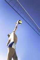 garoto joga vôlei em lindo dia de verão foto