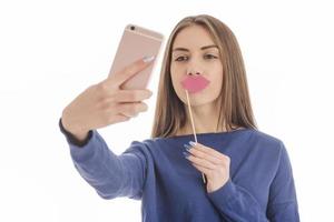 adolescente engraçada de beleza fazendo selfie com seu celular foto