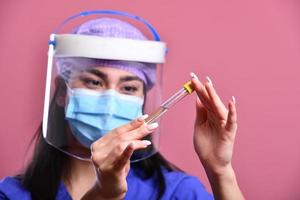 closeup médica asiática usando escudo facial e traje de proteção individual para surto de coronavírus foto
