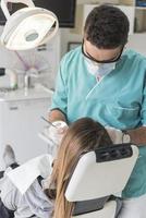 dentista curando os dentes do paciente preenchendo a cavidade. dentista trabalhando com equipamentos profissionais na clínica. foto