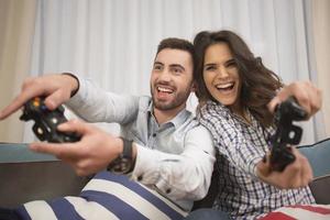casal sorridente feliz jogando videogame em casa. foto