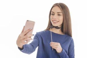 adolescente engraçada de beleza fazendo selfie com seu celular foto