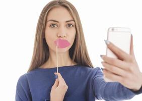 adolescente engraçada de beleza fazendo selfie com seu celular foto