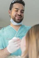 dentista curando os dentes do paciente preenchendo a cavidade. dentista trabalhando com equipamentos profissionais na clínica. foto