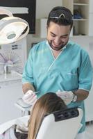 dentista curando os dentes do paciente preenchendo a cavidade. dentista trabalhando com equipamentos profissionais na clínica. foto