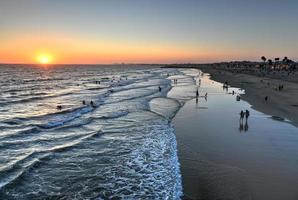 ondas no oceano pacífico e vista da praia ao pôr do sol, em newport beach, califórnia. foto