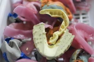dentaduras. isolar em prótese acrílica de fundo branco de mandíbulas humanas. o conceito de odontologia ortopédica foto