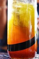 copo com suco refrescante no bar. coquetel cítrico com gelo, detalhes do coquetel de laranja foto