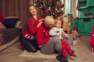 família jovem feliz com filha comemora o natal e o ano novo juntos foto