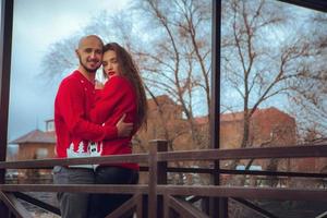 retrato de lindos abraços de casal em uma varanda no inverno. clima de natal foto