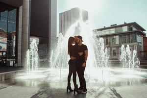 retrato de abraços de casal jovem glamour na fonte de rua foto