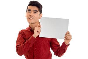 retrato de jovem elegante em camiseta vermelha com cartaz vazio nas mãos, isolado no fundo branco foto