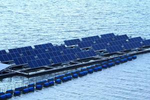 painel solar energia solar limpa flutua acima do rio acima da represa em um dia quente e ensolarado, perfeito para produzir energia para o futuro. foto