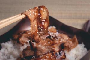 pauzinhos, carne de porco fatiada, molho japonês foto