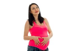 mulher grávida pensativa posando isolada no fundo branco foto
