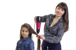 mãe secadora de cabelo das filhas pequenas foto