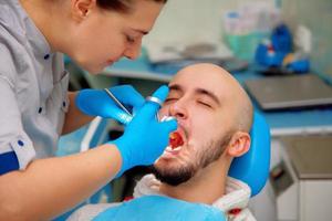 dentista profissional trata paciente de dentes foto