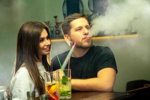 casal fuma shisha no bar foto