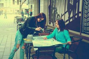 duas mulheres sentadas em uma mesa na rua foto