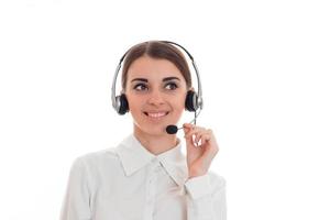 mulher de negócios jovem feliz trabalhando em call center com fones de ouvido e microfone olhando de lado e sorrindo isolado no fundo branco foto