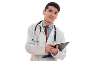 jovem médico de uniforme com estatoscópio olhando para longe e sorrindo isolado no fundo branco foto