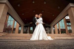 jovem casal em lindo terno de casamento abraçando foto