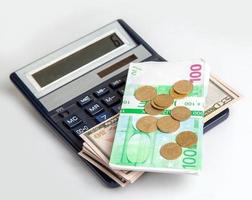 as notas estão em uma calculadora, dólares, euros e moedas foto