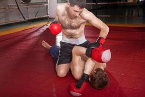 dois homens estão lutando boxe no ringue foto