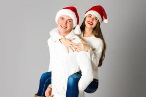 casal apaixonado comemora o natal com chapéu de papai noel foto