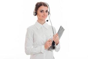 bela jovem morena chamada trabalhadora de escritório com fones de ouvido e microfone isolado no fundo branco foto