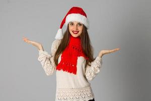 menina de chapéu de papai noel e lenço vermelho foto