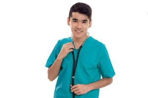 médico jovem alegre posando de uniforme isolado no fundo branco no estúdio foto