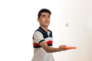 retrato de jovem desportista praticando tênis de mesa em uniforme no estúdio foto