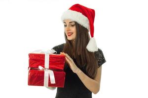 linda garota de chapéu de Papai Noel com caixa de presente vermelha foto