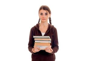 retrato de uma jovem estudante atraente em roupas esportivas marrons com muitos livros nas mãos, isolados no fundo branco foto
