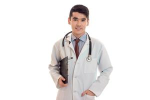 jovem médico masculino bonito com estetoscópio de uniforme isolado no fundo branco foto