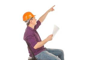 trabalhador da construção civil em um capacete com um plano na mão foto