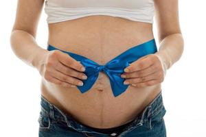 mulher grávida posando com fita azul na barriga dela isolada no fundo branco foto