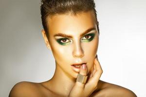 modelo de moda jovem com maquiagem de cores verdes, olhando para a câmera foto