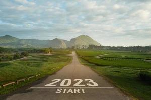 feliz ano novo 2023,2023 simboliza o início do ano novo. a carta começa o ano novo de 2023 na estrada na natureza, fazenda de chá verde fresco, ambiente de montanha, ecologia ou conceito de papel de parede verde. foto