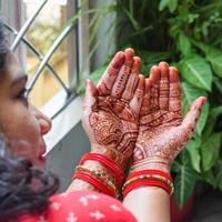 mulher bonita vestida como tradição indiana com desenho de henna mehndi em ambas as mãos para celebrar o grande festival de karwa chauth, celebrações de karwa chauth por mulher indiana para o marido foto