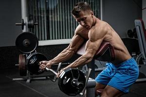 homem musculoso durante treino no ginásio foto