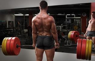 homem forte fazendo exercício deadlift no ginásio foto