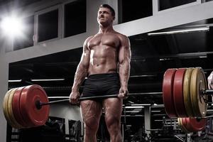 homem forte fazendo exercício deadlift no ginásio foto