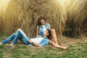 jovem casal adorável está relaxando entre os palheiros foto