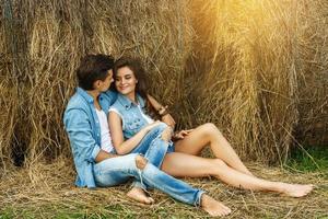 jovem casal adorável está relaxando entre os palheiros foto