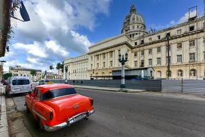 havana, cuba - 8 de janeiro de 2017 - carros estacionados em frente ao prédio da capital nacional em havana, cuba. foto