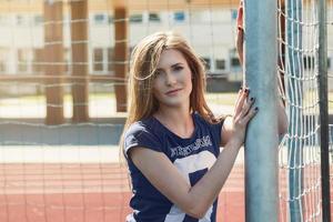 linda garota com bola no campo de futebol foto